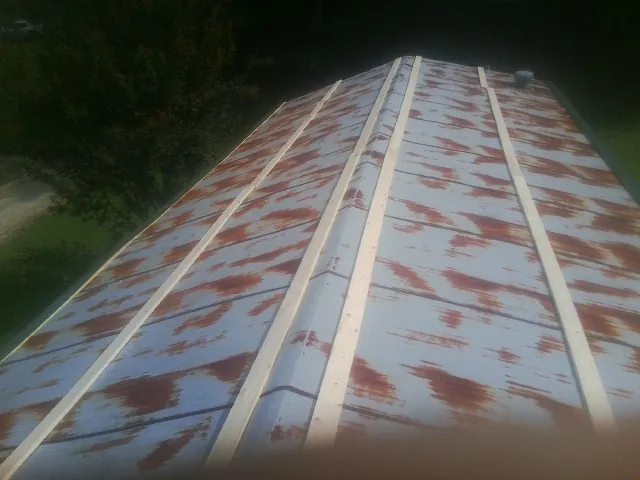 Rusted metal roof panels with new wood purlins before replacement — Storm Damage Roof Repair in Allenwood by Roofing Brothers