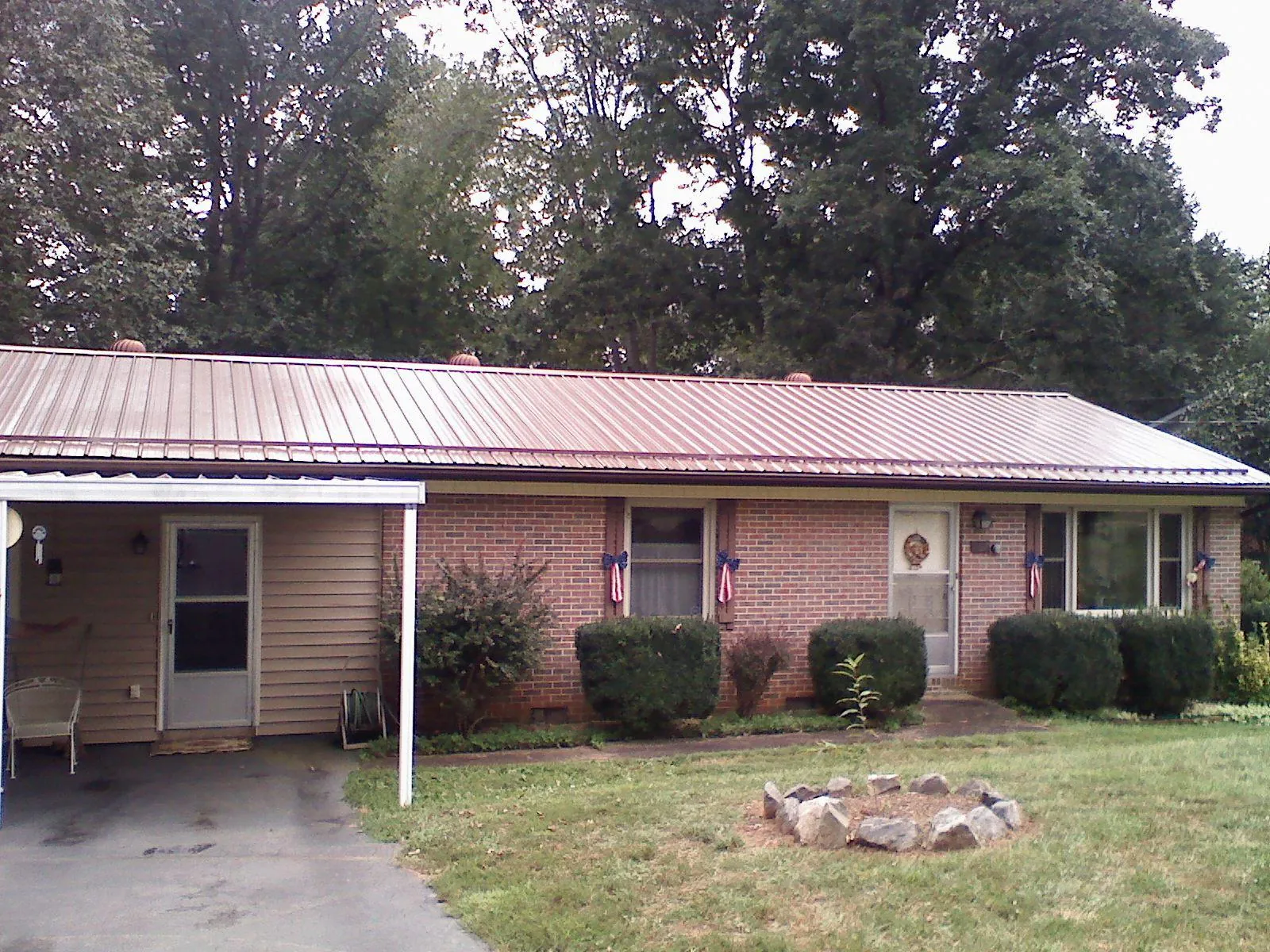 Bronze metal roof and carport on a brick ranch home — Roof Repair work by our crew in Allenwood